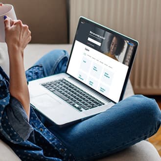 Une personne avec un ordinateur portable sur ses genoux regardant un matériel de support Payworks.
