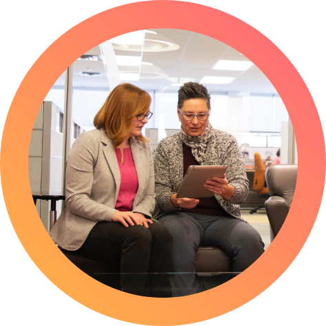 Coworkers looking at a tablet. Coworkers checking a tablet in an office sofa.